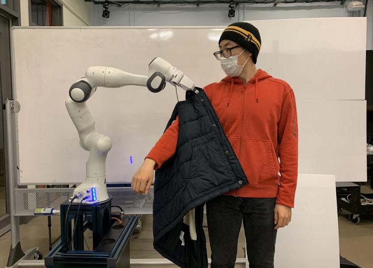 机器人帮助人类穿上夹克。