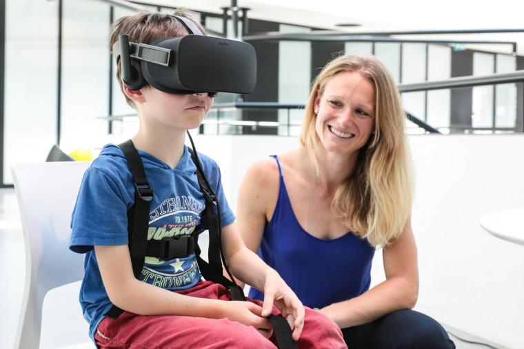 Jenifer Miehlbradt与一个6岁的孩子尝试虚拟现实游戏。