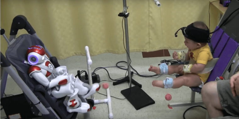婴儿与Nao机器人互动。